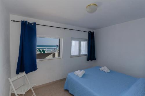 um quarto com uma cama azul e uma janela em Casa Miramare em Mattinata