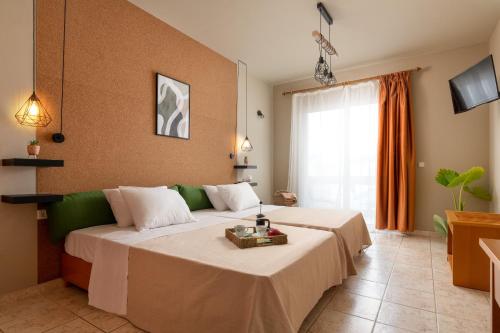 Habitación de hotel con cama y TV en GOJI Vegan Hotel, en Ialisos