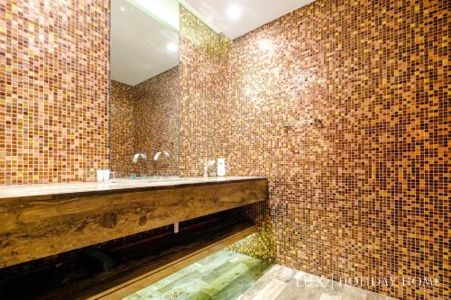 a bathroom with brown tiled walls and a sink at LUX - Lavish Suite with Full Palm Jumeirah View 2 in Dubai