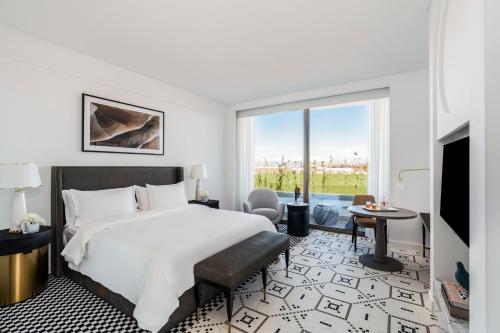 a hotel room with a bed and a large window at Fairmont La Marina Rabat Sale Hotel in Rabat