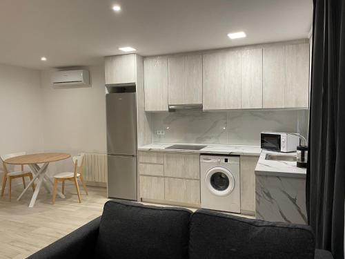 cocina con lavadora y mesa en Apartamentos Barcelona - Iberia en Barcelona