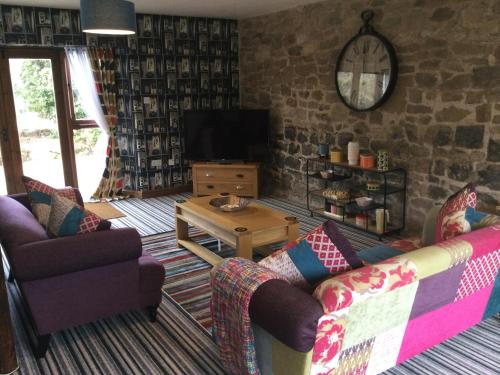 uma sala de estar com dois sofás e uma televisão em Upper Home Farm em Plaish