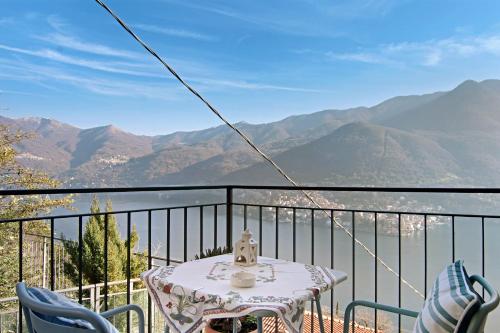 a table and chairs on a balcony with a view of mountains at Renovated Barn of the year 1500 in Moltrasio
