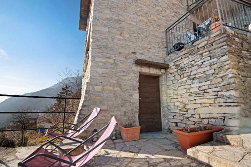 two lawn chairs sitting outside of a stone building at Renovated Barn of the year 1500 in Moltrasio