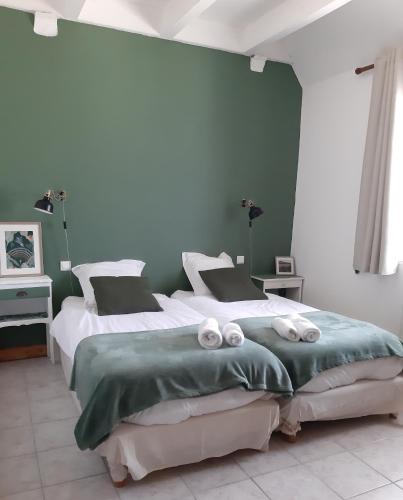 - 2 lits dans une chambre aux murs verts et blancs dans l'établissement La Chouette Burgonde, à Villy-le-Moutier