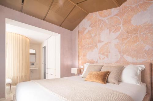 a bedroom with a white bed with a floral wall at Ninfea Luxury Suites in Venice