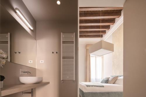 een badkamer met een wastafel, een bed en een spiegel bij Ninfea Luxury Suites in Venetië