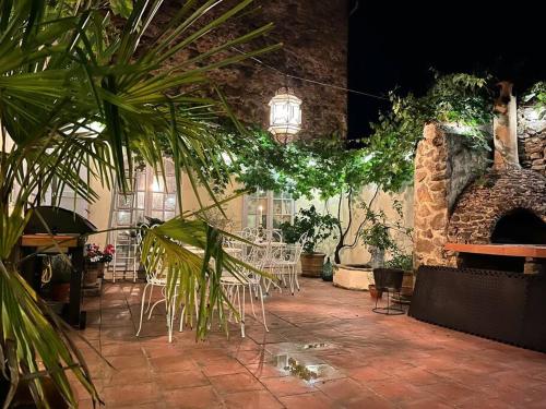 a room with a table and chairs and plants at La Maison de Mama C: Charming french village home in Sainte-Colombe-sur-lʼHers