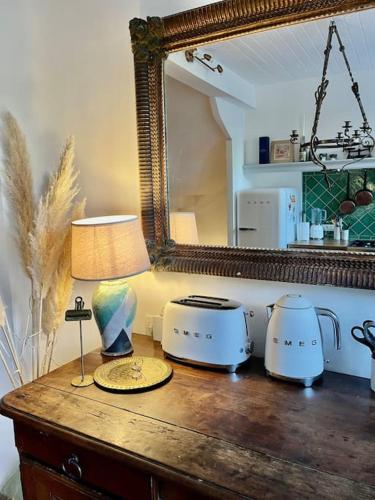 - une table avec un miroir et une lampe dans l'établissement La Maison de Mama C: Charming french village home, à Sainte-Colombe-sur-lʼHers