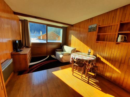 une pièce avec une table, une chaise et une fenêtre dans l'établissement Studio meublé montagne, à Saint-Léger-les-Mélèzes