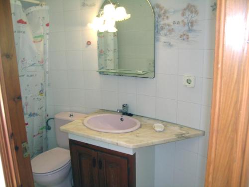 a bathroom with a sink and a toilet and a mirror at La gervaise in Begur