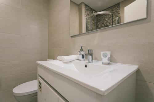 La salle de bains est pourvue d'un lavabo blanc et de toilettes. dans l'établissement Best Houses 53 - Costa Mar II, à Consolação