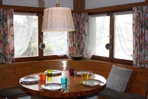 a dining room with a table and chairs and windows at Unterkunft MECK-HEI in Wildhaus