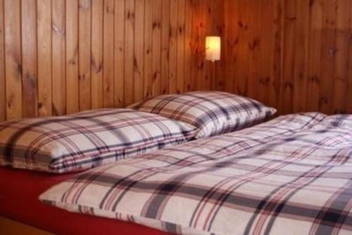 two twin beds in a room with wooden walls at Unterkunft MECK-HEI in Wildhaus
