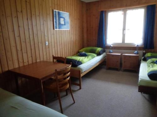 Zimmer mit 2 Betten, einem Tisch und einem Schreibtisch in der Unterkunft Manser, Ferien beim Bauer 1 Stock in Oberhegi