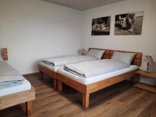 Habitación con 2 camas individuales y suelo de madera. en Wydhof Ferienwohnung, en Flaach