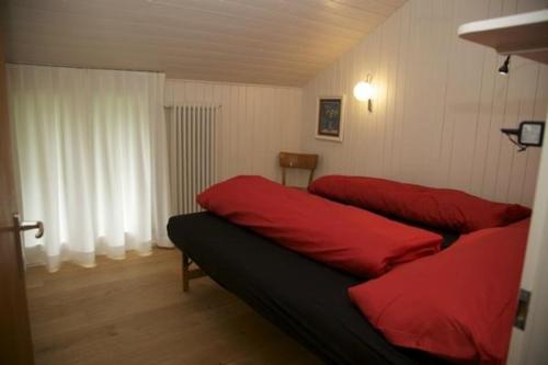 a bedroom with two red beds in a room at Ferienhaus Befang 17 in Wildhaus