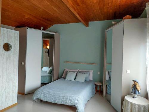 1 dormitorio con 1 cama con paredes azules y techo de madera en Maison conviviale aux abords de la vieille ville, en Boulogne-sur-Mer