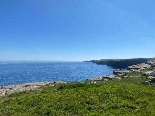 a view of the ocean from a hill at Hot Tub Haven Farr North 2 in Wick