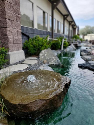 a rock in the water in front of a building at Three Forks Lewis & Clark Motel in Three Forks