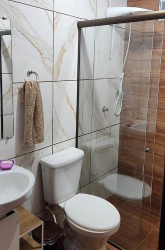 a bathroom with a toilet and a shower and a sink at 300m-da Av das Cataratas- Ar Condicionado - Estacionamento Privado in Foz do Iguaçu