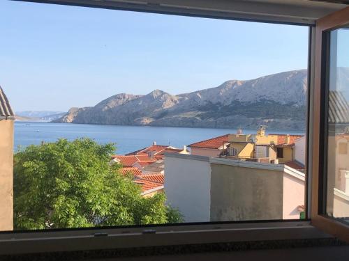 a window with a view of the water and mountains at Studio Neven with Sea View in Baška