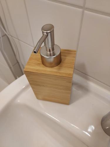 a bathroom sink with a faucet in a wooden holder at Cosy Place for one/two in Berlin