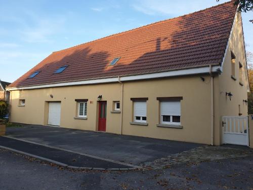 a building with a red door and a roof at Au Relais Du Canal à Grand Gabarit in Nesle