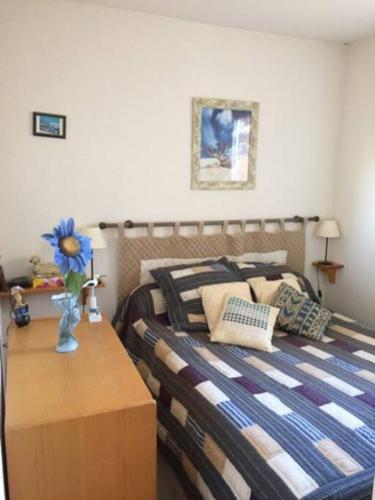 - une chambre avec un lit et un vase avec une fleur sur une table dans l'établissement La Londe les pieds dans l'eau, à La Londe-les-Maures