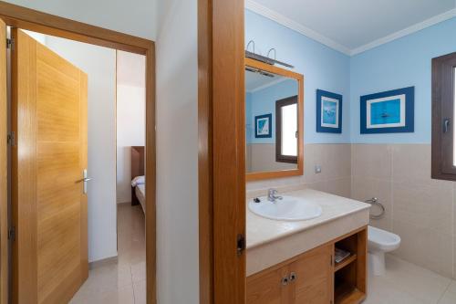 プラヤ・ブランカにあるVilla Albaのバスルーム(洗面台、トイレ、鏡付)
