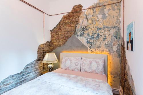 a bed in a room with a brick wall at By Galata- Historical and Modern Apartment in Istanbul