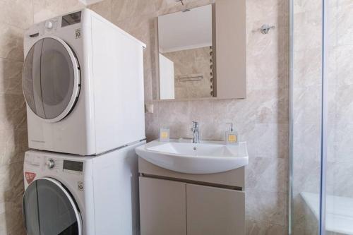 a bathroom with a washing machine and a sink at Picturesque Gated Beach-Front Private Villa at Lefkathia Beach, Chios! in Volissos