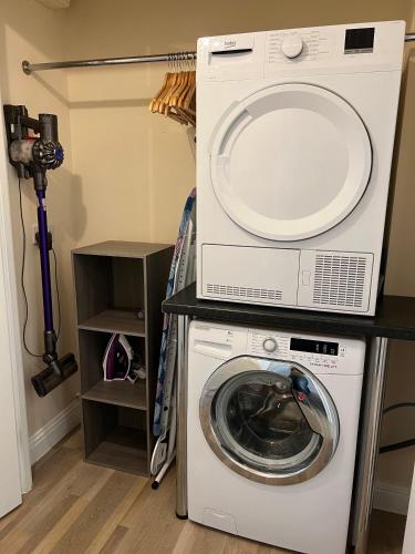a washer and dryer with a microwave on top of it at Glastonbury High Street Sanctuary- 2 BD, Sleeps 4 in Glastonbury