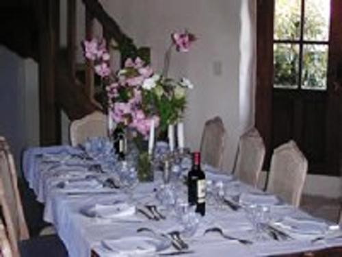 a long table with glasses and a bottle of wine at Maison spacieuse avec jardin à Morannes sur Sarthe in Saint-Germain