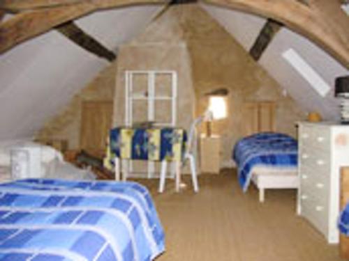 une chambre avec deux lits dans un grenier dans l'établissement Maison spacieuse avec jardin à Morannes sur Sarthe, à Saint-Germain