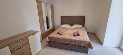 a bedroom with a bed with two shoes on it at Stone House in Pridraga