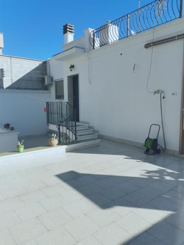 a white building with a staircase and a patio at M&G Maison in Crispiano