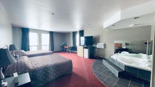 a hotel room with a bed and a bath tub at Motel Falcon in Brossard