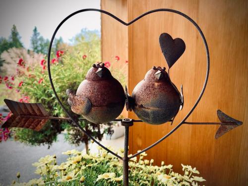 two birds on a heart sign in a garden at Haralds exklusives Ferienhaus in Langenegg in Langenegg