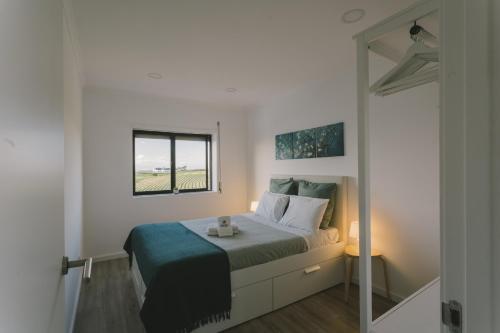 a white bedroom with a bed with a window at Best Houses 73 - Lovely view São Bernardino in Atouguia da Baleia