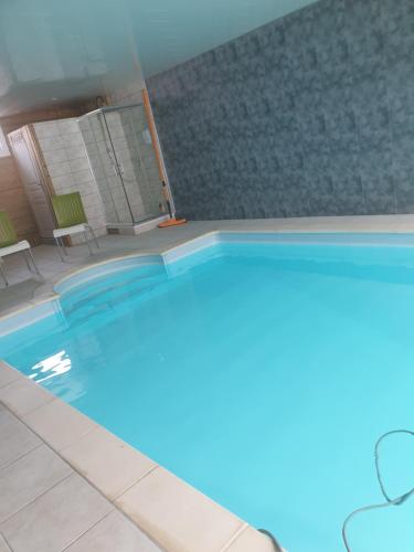 einen großen Pool in einem Zimmer mit Fliesenboden in der Unterkunft Au Chardon Bleu in Nesle