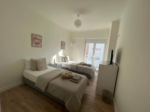 a bedroom with two beds and a flat screen tv at Modern Twin Room with a balcony in Montijo