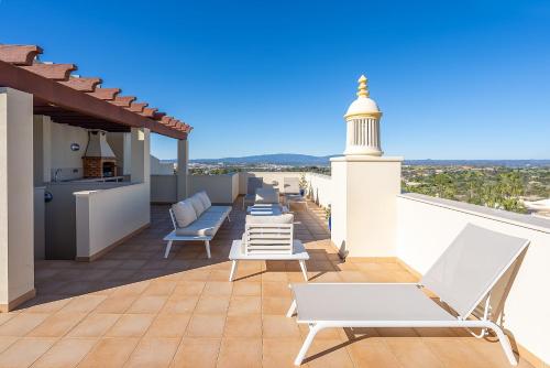 a patio with chairs and a lighthouse on a roof at Casa Saudade - Luxury penthouse apartment with stunning views in Estômbar