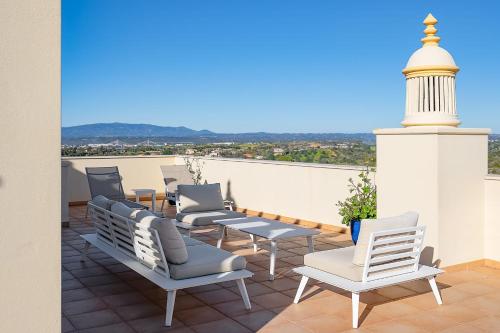 een groep stoelen op een dak bij Casa Saudade - Luxury penthouse apartment with stunning views in Estômbar