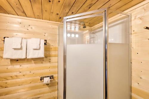a glass shower in a bathroom with wooden walls at stayNantahala - Smoky Mountain Cabins in Aquone