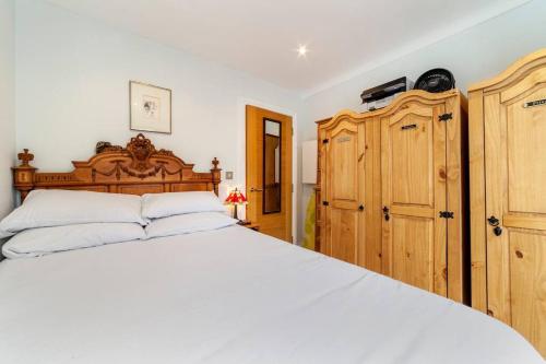 - une chambre avec un grand lit blanc et des placards en bois dans l'établissement Outstanding Antique 1BR flat in Soho, à Londres