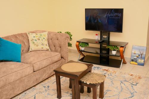 sala de estar con sofá y TV de pantalla plana en Classic beautiful 2-Bedroom Apartment in Thika, en Thika