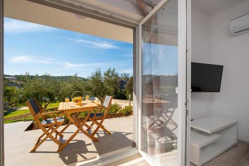 a glass extension of a house with a table and chairs at Apartmani Stari ribar in Lovište