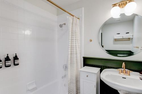 Baño blanco con lavabo y espejo en Suite 2 Historic Art City Inn, en Springville