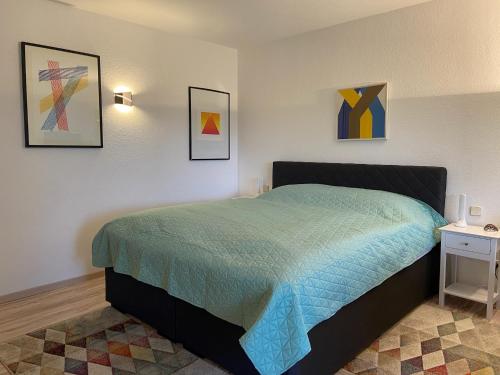 a bedroom with a bed with a blue comforter at Waldwerk Wurlgrund Lychen in Lychen